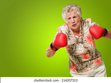 Angry Mature Woman Wearing Boxing Glove Isolated On Green Background