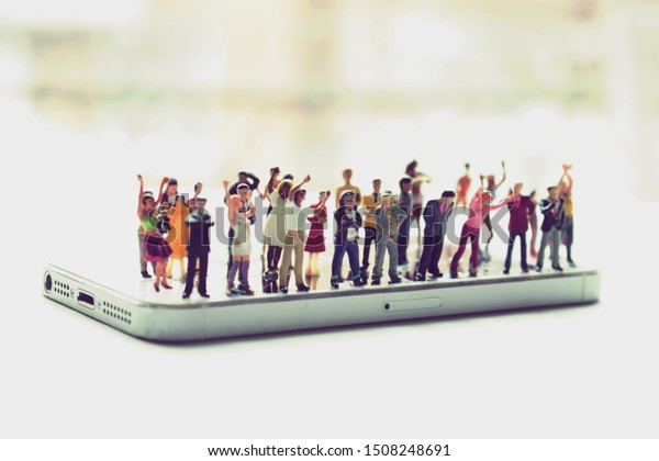 Angry mob of various, diverse people on a\
phone. Social media addiction concept or people mistreating one\
another online. Group mentality or cancelled culture. Men and women\
arguing over politics.
