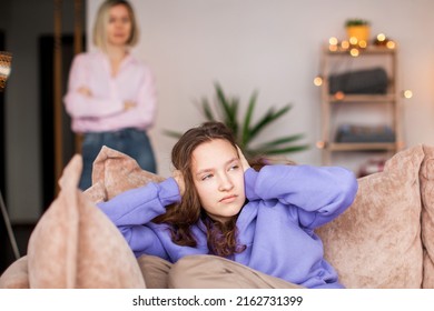 Angry Mom Scolds Her Teen Daughter At Home. Girl Ignoring Her Mom. Troubled Teenage Child And Her Mother Are Quarreling 