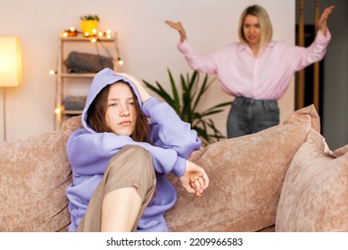 Angry Mom Scolds Her Teen Daughter At Home. Girl Ignoring Her Mom. Troubled Teenage Child And Her Mother Are Quarreling 