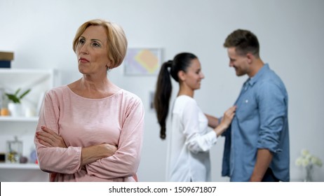 Angry Mother With Hands Crossed, Couple In Love On Background, Lack Of Attention