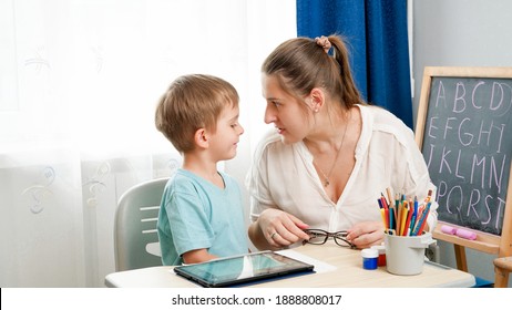 ANgry Mother Looking In Face Of Her Little Son Being Silly While Doinghomework At Remote Home School Lesson.