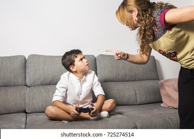 Angry mother nags her son because he plays at video games