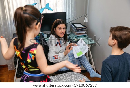 Angry mother scolding her children who interrupt her while telecommuting at home. Conciliation family work concept