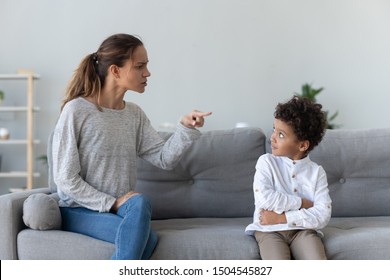 Angry Mother Scolding Naughty Little African American Boy, Sitting On Couch At Home, Strict Mum Blaming, Lecturing Son, Demanding Discipline, Bad Family Relationship, Mom And Kid Conflict