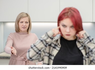 Angry Mother Scolds Her Teen Daughter. Girl Covers Her Ears And Ignores Her Mother. Family Relationships Concept