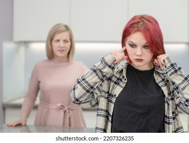 Angry Mother Scolds Her Teen Daughter At Home. Girl Plugged Her Ears And Ignores Her Mother. Family Relationships Concept