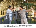 Angry neighbours having argument near fence outdoors