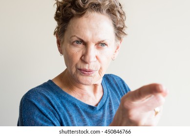 Angry Older Woman In Blue Top Pointing Finger (selective Focus)