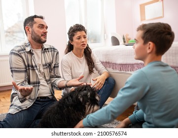 Angry Parents Having Serious Talk With Boy In His Room, Sitting On Floor