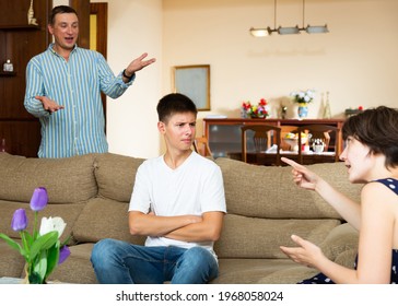 Angry Parents Scolding Their Sad Young Son In Living Room