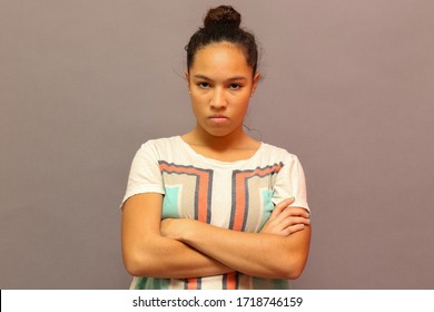 Angry Racially Mixed Teen Girl Standing With Her Arms Crossed And With An Expression Of A Bad Attitude.