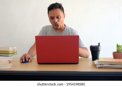 Angry Reaction Of Man Looking At Laptop While Work At Home, Funny Rage Asian Guy In Front Of Computer Desk, Unfriendly Expression Face Isolated In White