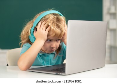 Angry Sad Child Using Laptop Computer, Kid Boy Studying Through Online E-learning. Little Funny System Administrator.