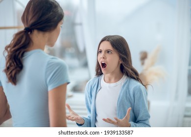 Angry Screaming Teen Girl And Listening Mom