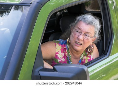 Angry Senior Woman Driver With Road Rage Yelling Out Car Window.