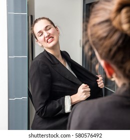 Angry Smart Young Woman Losing Temper In Front Of Her Mirror, Breaking Down, Tearing Out Her Business Suit For Exasperated Body Language