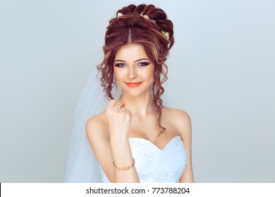 Angry spouse. Beautiful, pretty, smile woman in wedding dress girl, bride, lady  shows her hand with a fist. Isolated light blue background with copy space