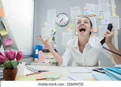 Angry Stressed Businesswoman In Office Shouting At Phone.