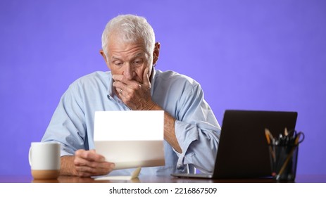 Angry Stressed Elderly Man 70s, Opening Envelope Reading Bad News In Mail Letter. Mad Man Feels Frustrated About High Bills, Bank Debt, Tax Invoice Or Mistake Isolated On Purple Background