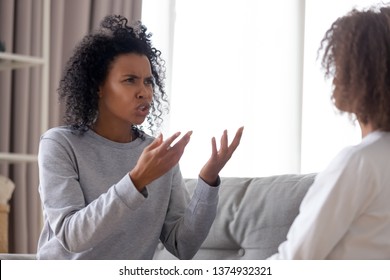 Angry Strict African American Mother Shouting At Teenage Daughter, Annoyed Mum Lecturing, Scolding For Discipline Rebellious Naughty Teen Girl Child, Family Conflict, Fight Or Quarrel Concept