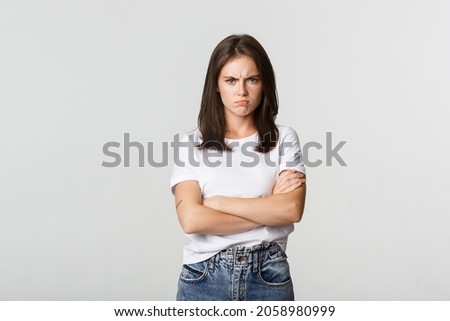 Angry sulking girl cross arms and frowning, feeling offended