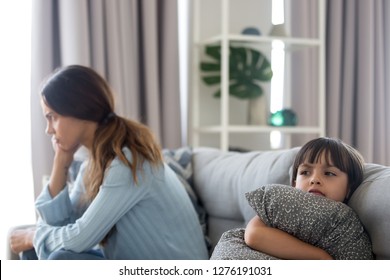 Angry Sulky Child Girl And Annoyed Mother Sitting Back To Back On Sofa Not Talking After Fight, Stubborn Kid Daughter Pouting Ignoring Mom Upset By Quarrel, Family Conflict Disagreement Concept