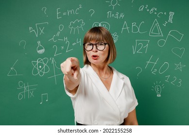 Angry Teacher Elderly Lady Woman 55 Wear Shirt Glasses Point Index Finger Camera On You Motivating Encourage Isolated On Green Wall Chalk Blackboard Background Studio. Education In High School Concept