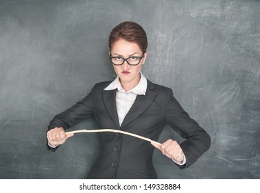 Angry Teacher In Glasses With Wooden Stick