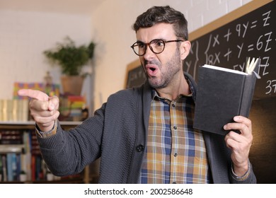 Angry Teacher Pointing With Finger In Classroom