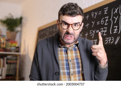 Angry Teacher Pointing With Finger In Classroom