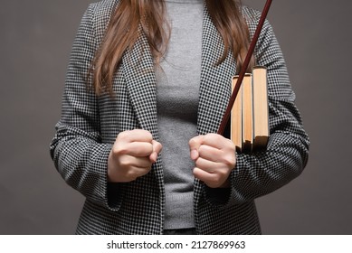 Angry Teacher With A School Pointer Stick And Books Shakes Her Fists.