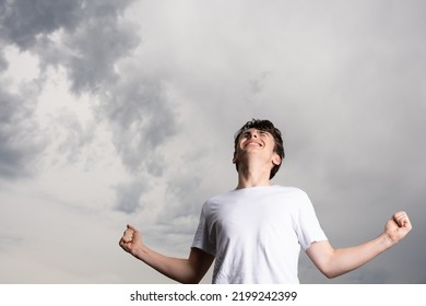 Angry Teenager Boy Looking Up At Dramatic Sky. Adversity, Anxiety And Stress Concept.