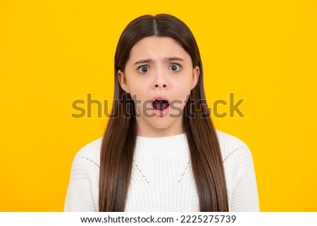 Angry teenager girl, upset and unhappy negative emotion. Close-up portrait of girl teen face. Portrait of a cute teen child. Studio shot, isolated background.