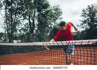 Angry Tennis Player Hitting A Net With Racket