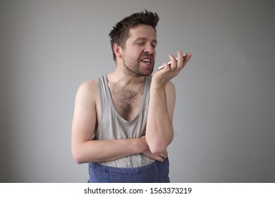 Angry Untidy Man Giving Voice Command To His Phone. Leave A Voice Message