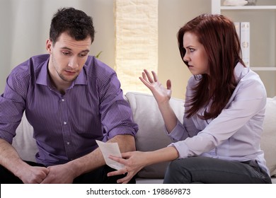 Angry Wife Showing Bills To Her Husband