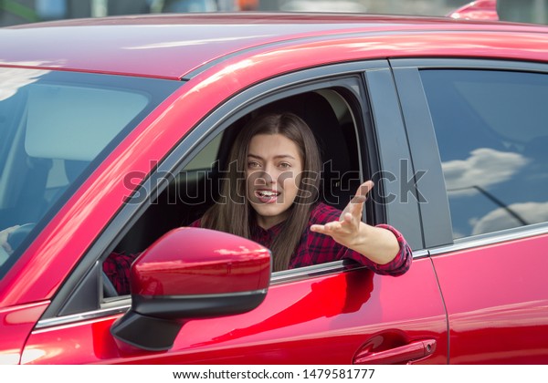 Angry woman driver screaming in the car. The\
quarrel and dissatisfaction on the\
way.