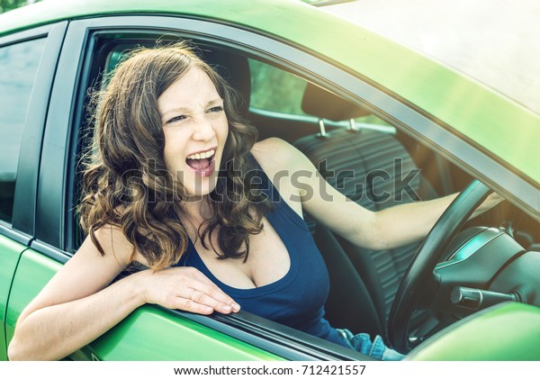 Angry woman driver screaming in the car. The\
quarrel and dissatisfaction on the\
way.