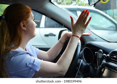 Angry Woman Driver Shows Hand Gesture To Other Drivers. Traffic Jams Concept.