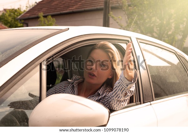 Angry woman driving\
car.