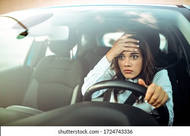 Angry woman driving a car. The girl with an expression of displeasure is actively gesticulating behind the wheel of the car. Angry business woman in a car. Stress girl in a car