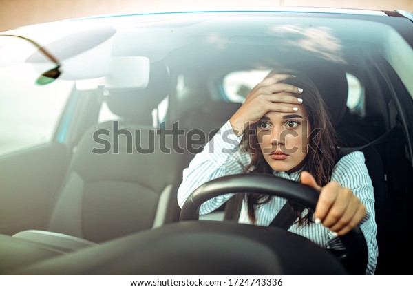 Angry woman driving\
a car. The girl with an expression of displeasure is actively\
gesticulating behind the wheel of the car. Angry business woman in\
a car. Stress girl in a\
car