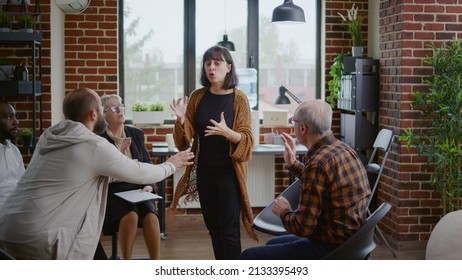 Angry Woman Explaining Mental Health Issues To Therapist And People At Aa Group Therapy. Desperate Person With Anger Management Problems Asking For Help From Psychologist.