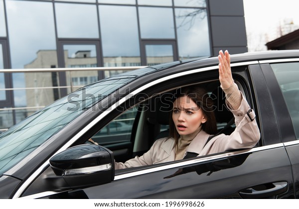 angry woman\
gesturing while driving car in\
city