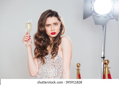 Angry Woman Holding Glass Of Champagne And Looking At Camera