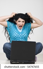 Angry Woman Pulling  And Tearing Out Her Hair And Screaming In Front Of Laptop Because Of Computer Crashed ,data Loss Or  Is Scared Of Something