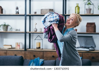 Angry Woman Throwing Clothes In Living Room After Breaking Up With Boyfriend