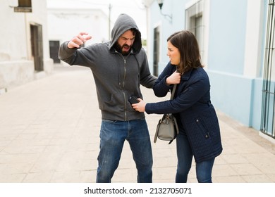 Angry Woman Victim Using A Stun Gun For Self-defense To Prevent An Assault Or Robbery While Alone On The Street