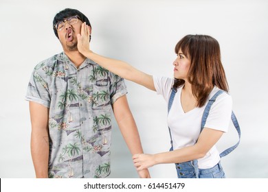 Angry woman in white shirt &bib jeans giving a slap in the face to her husband isolated on white background, a woman is hitting her husband, domestic violence concept